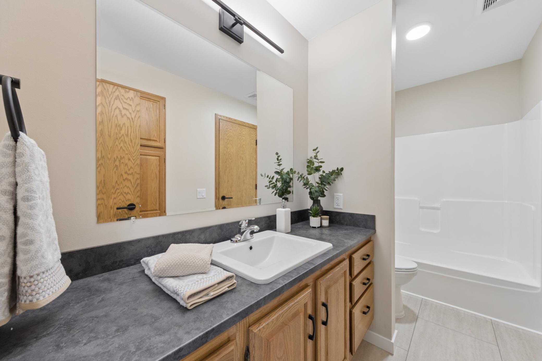 Beautifully refreshed upper-level bathroom featuring brand-new LVP flooring, an updated vanity top and sink, and a new toilet.