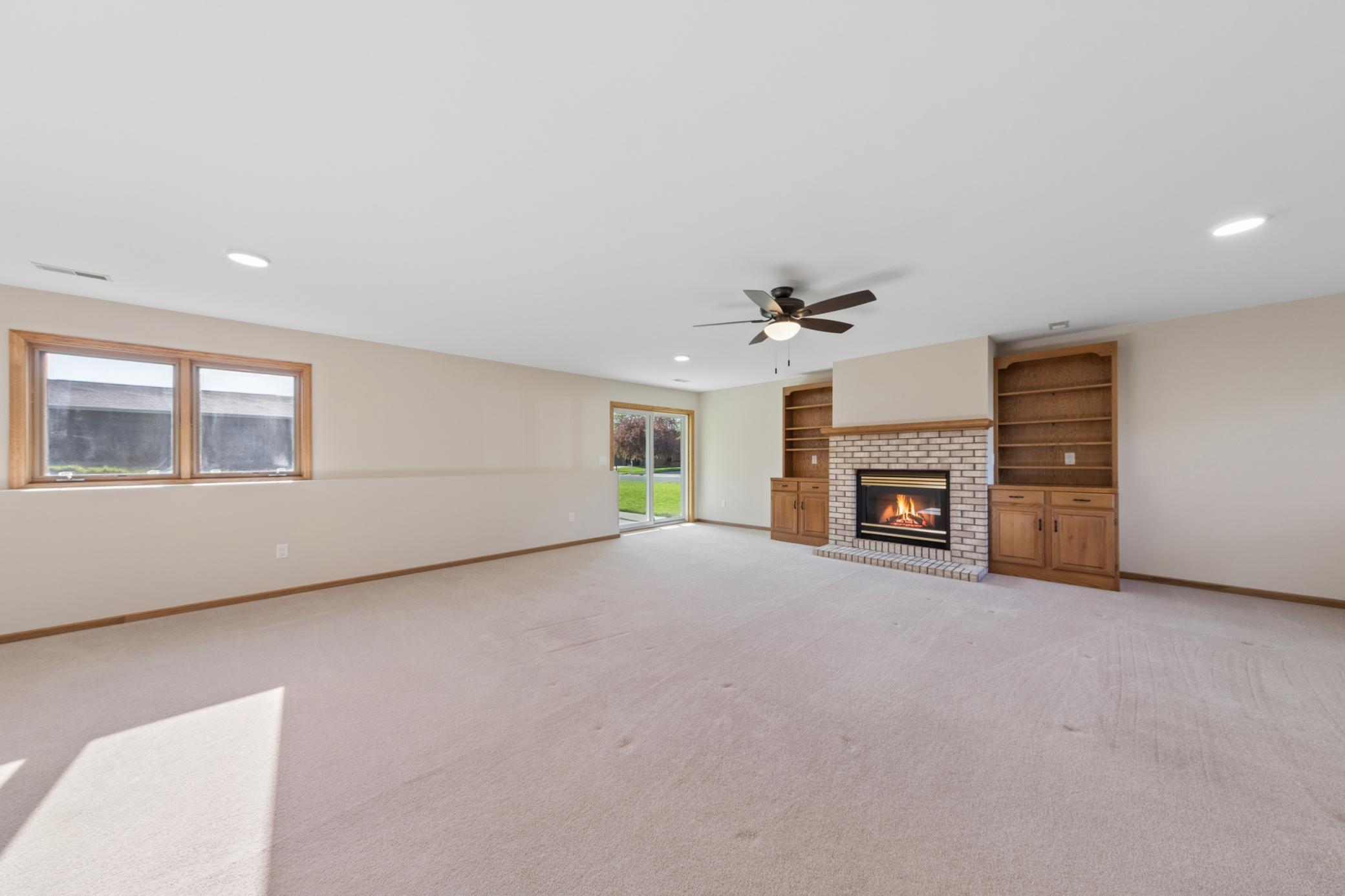 Expansive lower-level family room, perfect for movie nights or entertaining, featuring a cozy fireplace as a focal point. Offers seamless walkout access to the backyard.