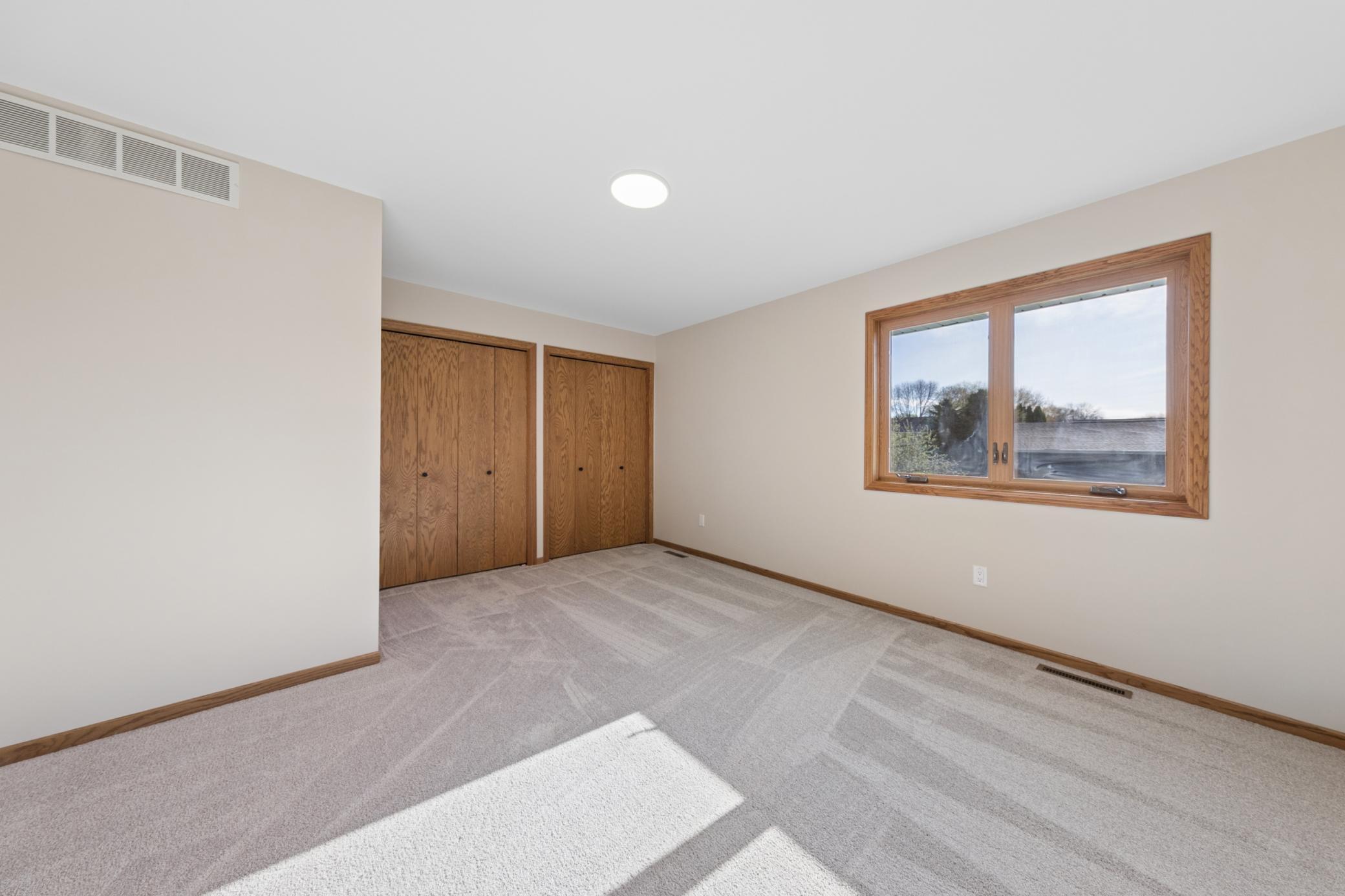 Bright secondary bedroom on the upper level, perfect for guests, family, or a dedicated home office. Offers a peaceful view and ample closet space.