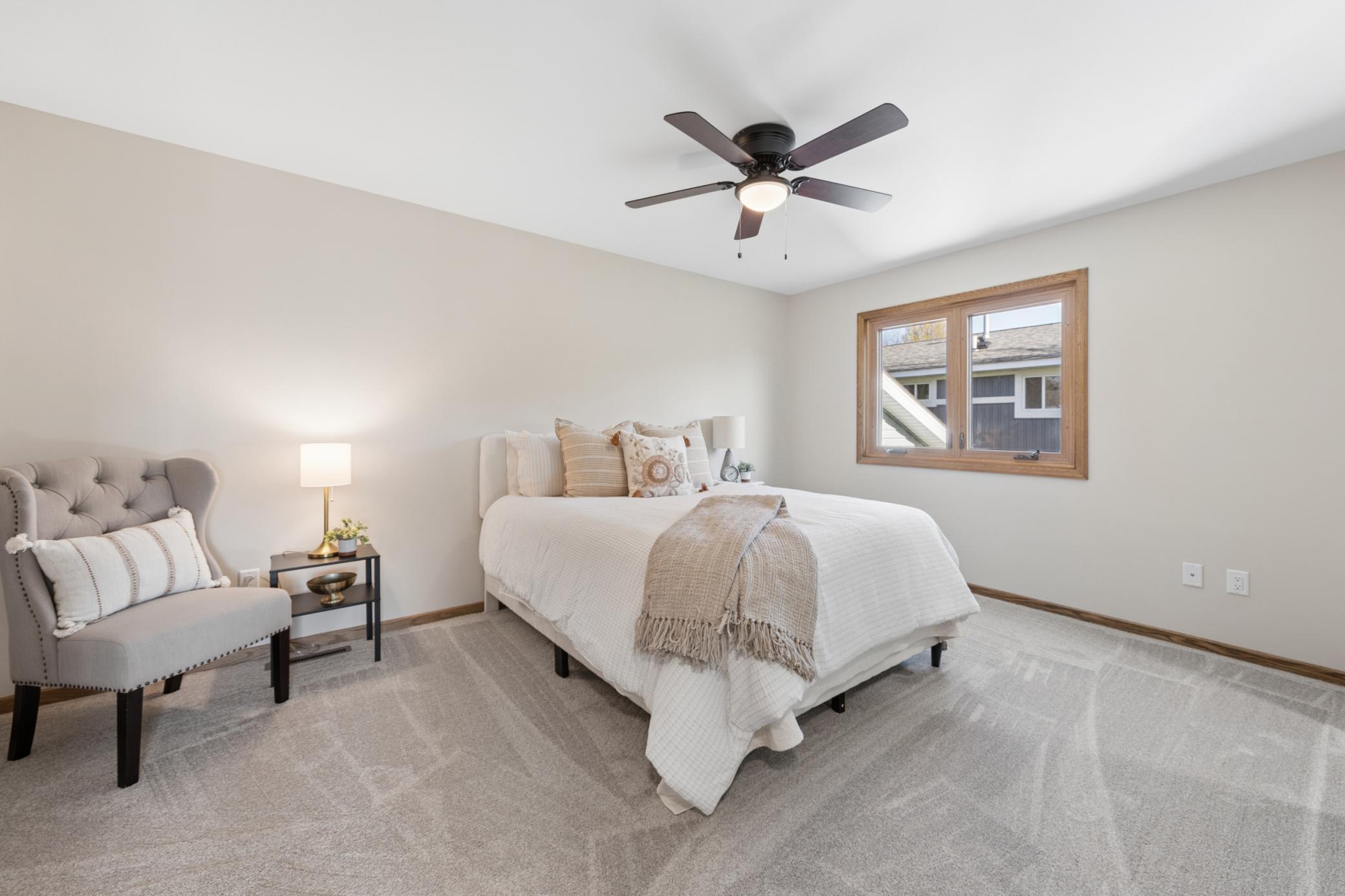 Spacious primary bedroom retreat featuring fresh paint, new carpeting, and abundant natural light.