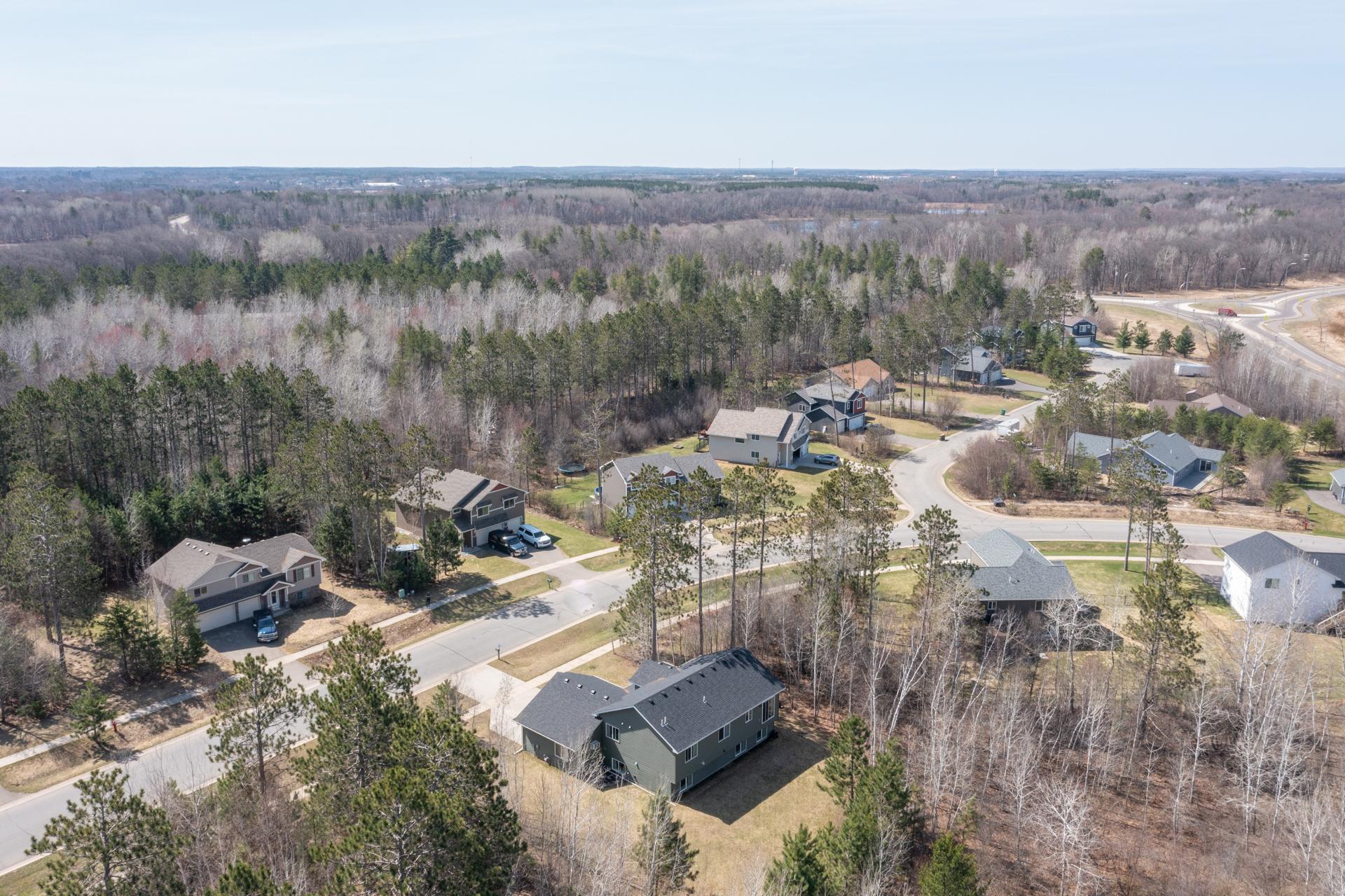 Expansive backyard surrounded by mature trees.