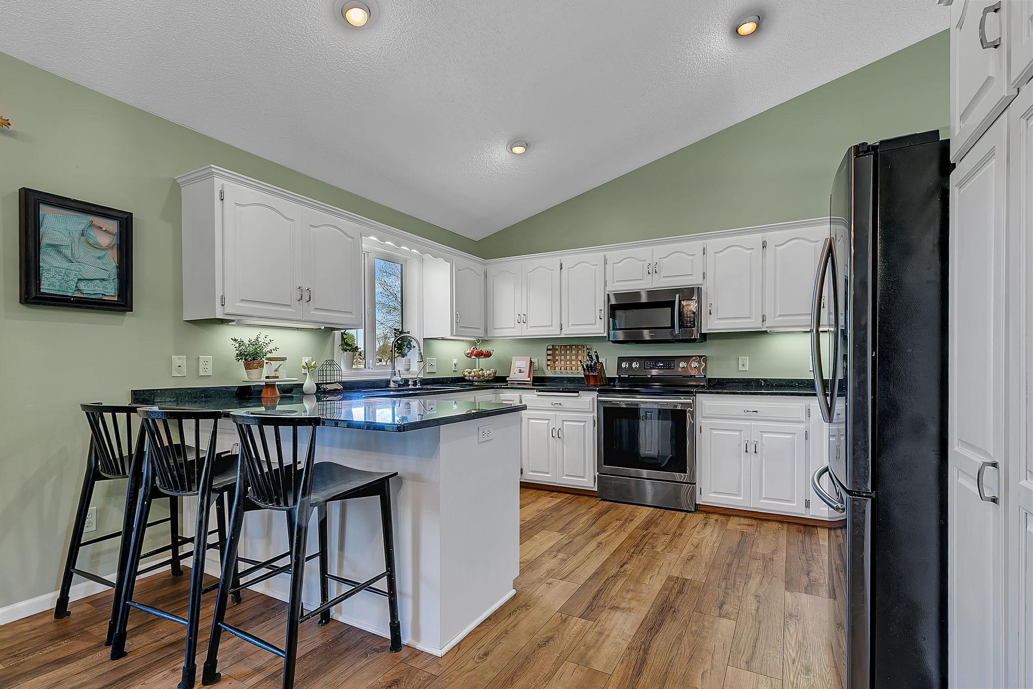 Slate stainless steel appliances, granite countertops, sink with backyard views + eat-in kitchen peninsula