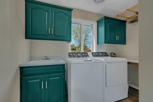 Centrally located laundry room with wash tub, folding table and drying racks + great natural light