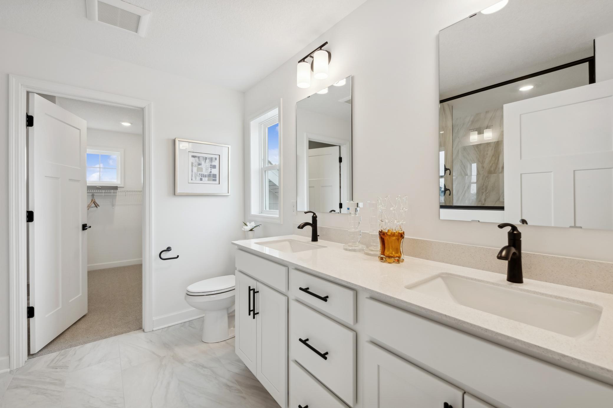 (Photo of a decorated model, actual homes finishes will vary) The primary bath includes a double vanity and a serenity shower.
