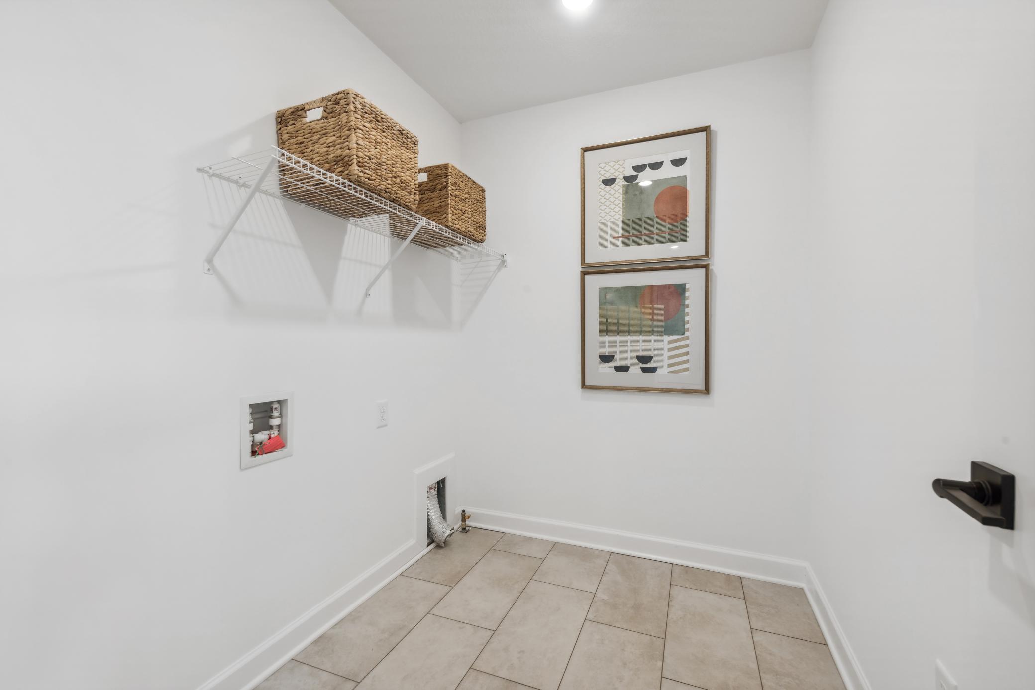 (Photo of decorated model, actual homes finishes will vary) Upper level laundry room is set up for a gas dryer.