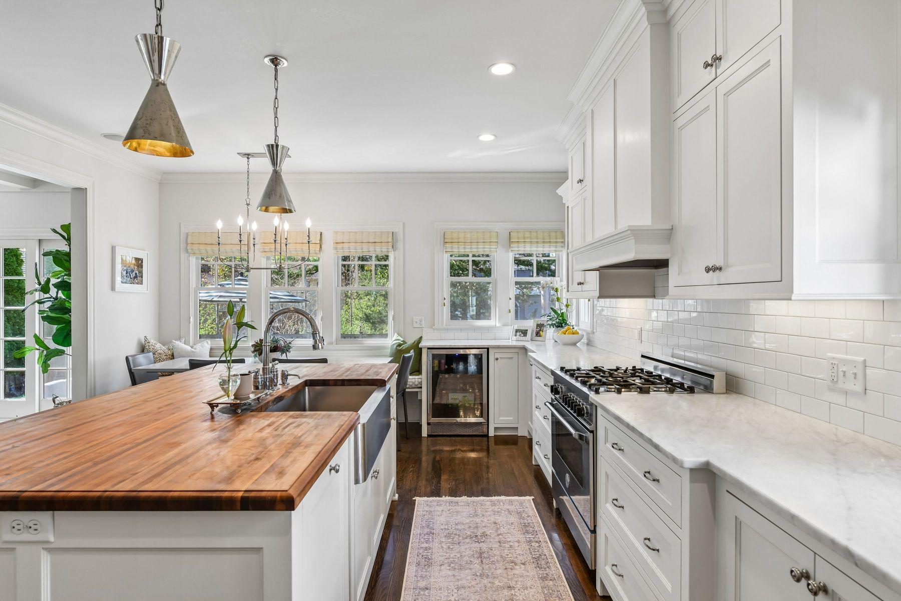 Walnut island , Carrera marble countertops, high end appliances, and gorgeous nickel light fixtures.