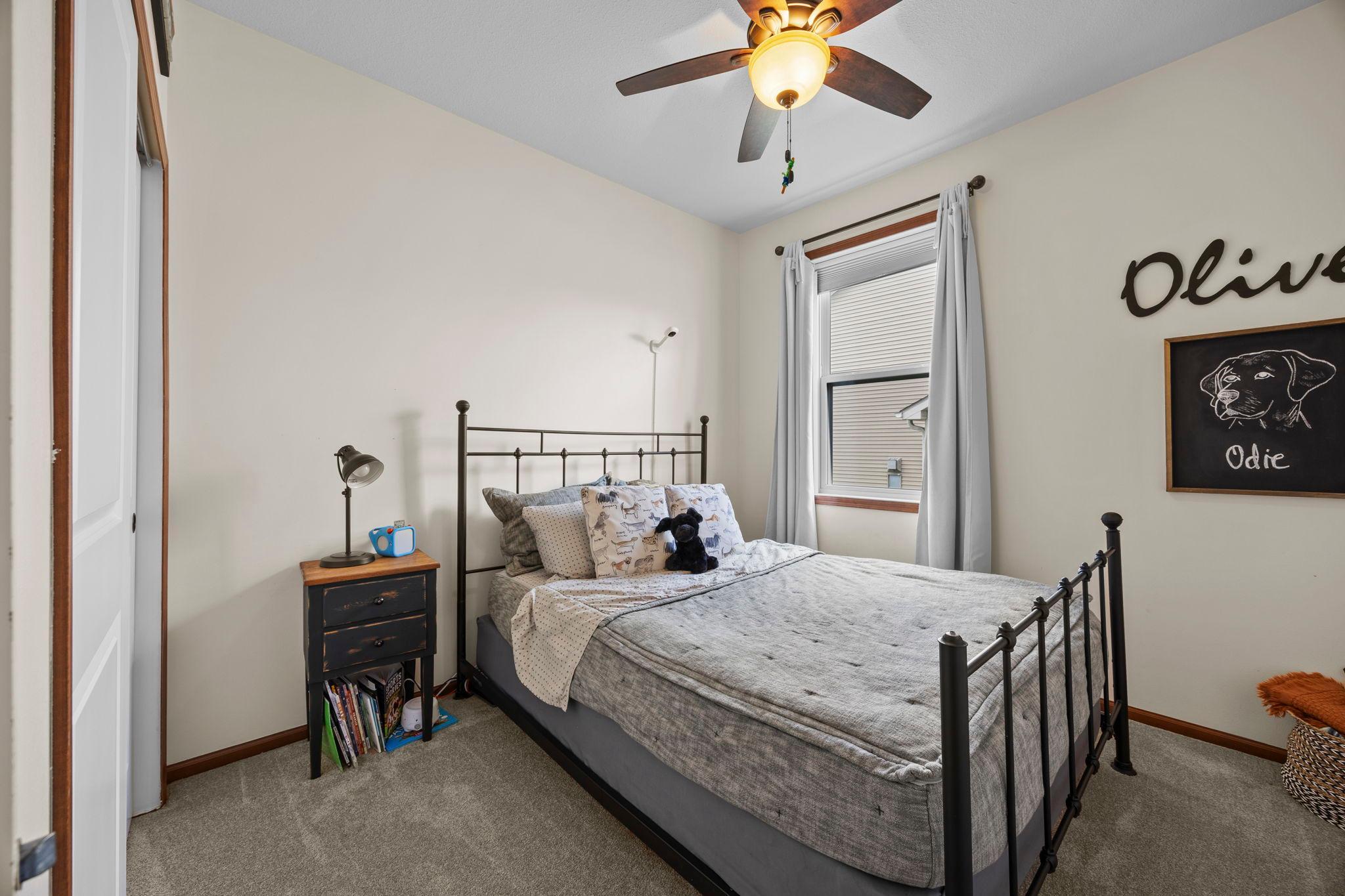 The second bedroom, located near the front of the home, includes carpeting, a ceiling fan, and a large closet, with access to a walk-through full bathroom.