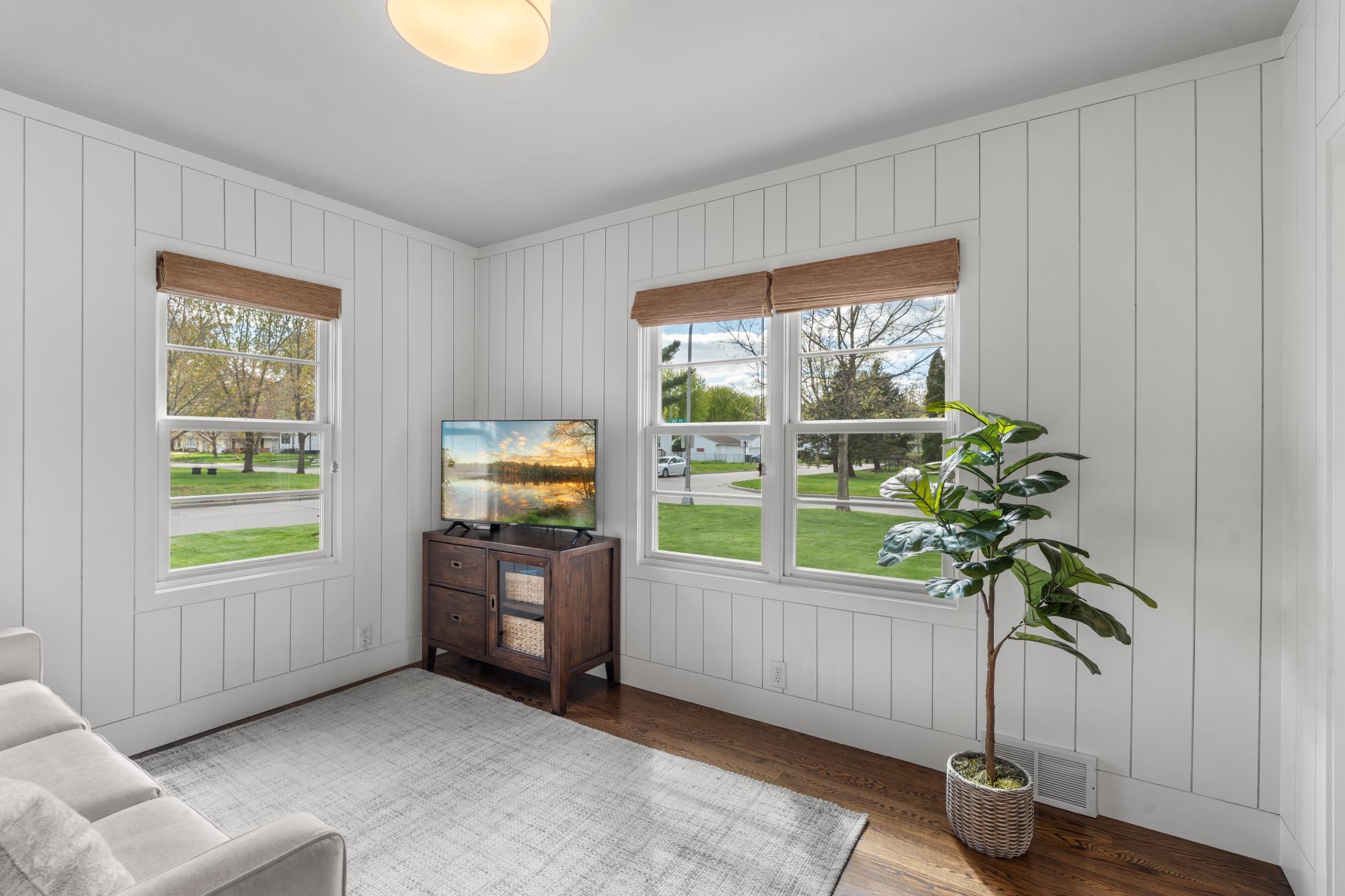 A sun-filled front sitting room provides peaceful neighborhood views.