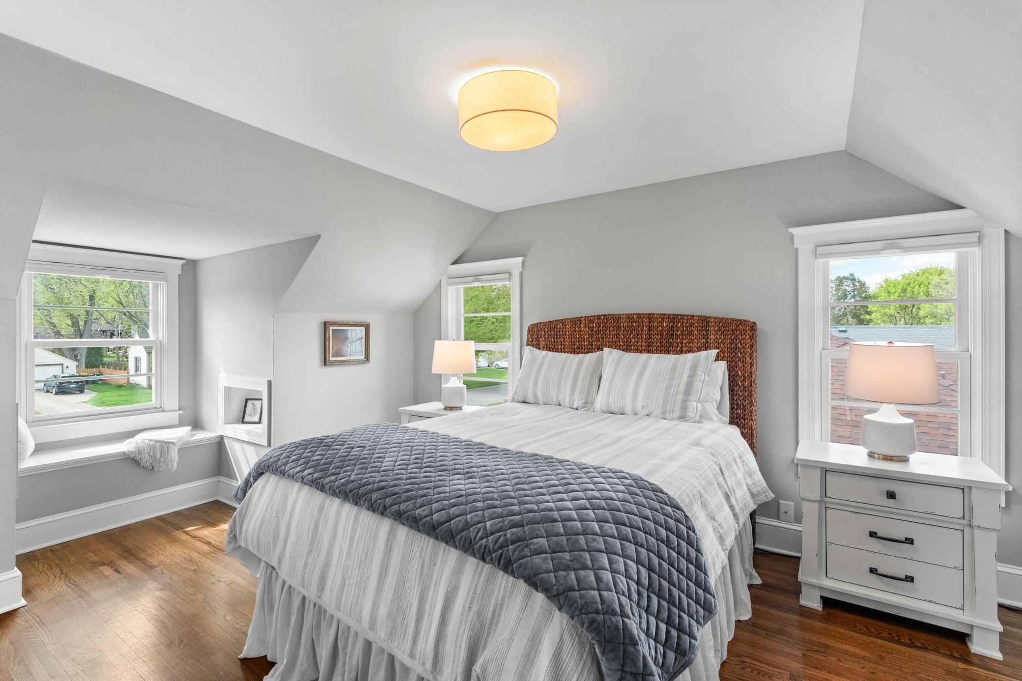 The second bedroom features hardwood flooring, a cozy reading nook with a built-in bench, and generous closet space.