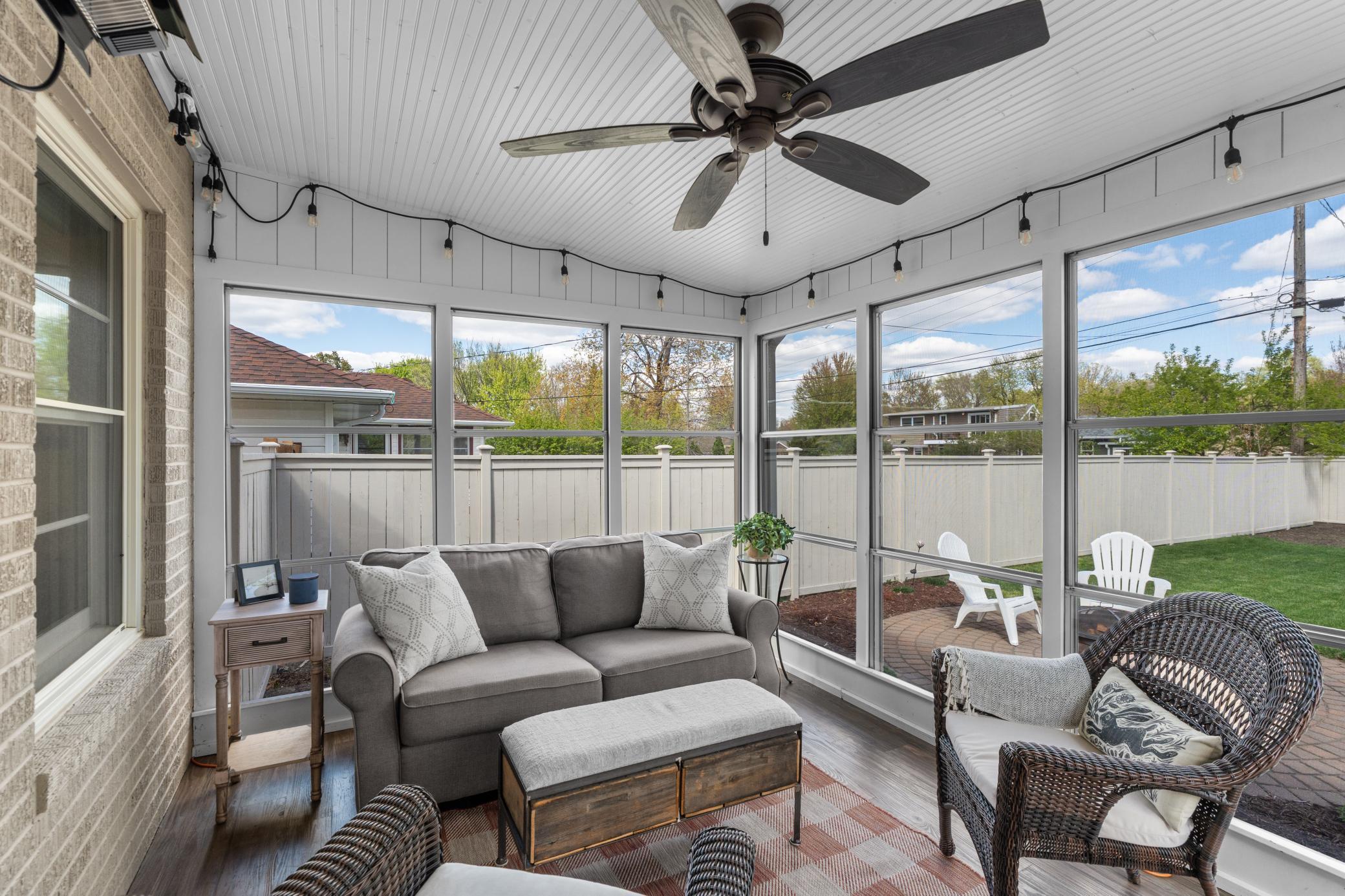 The inviting porch includes luxury plank flooring, a ceiling fan, and a supplemental heater for added comfort.