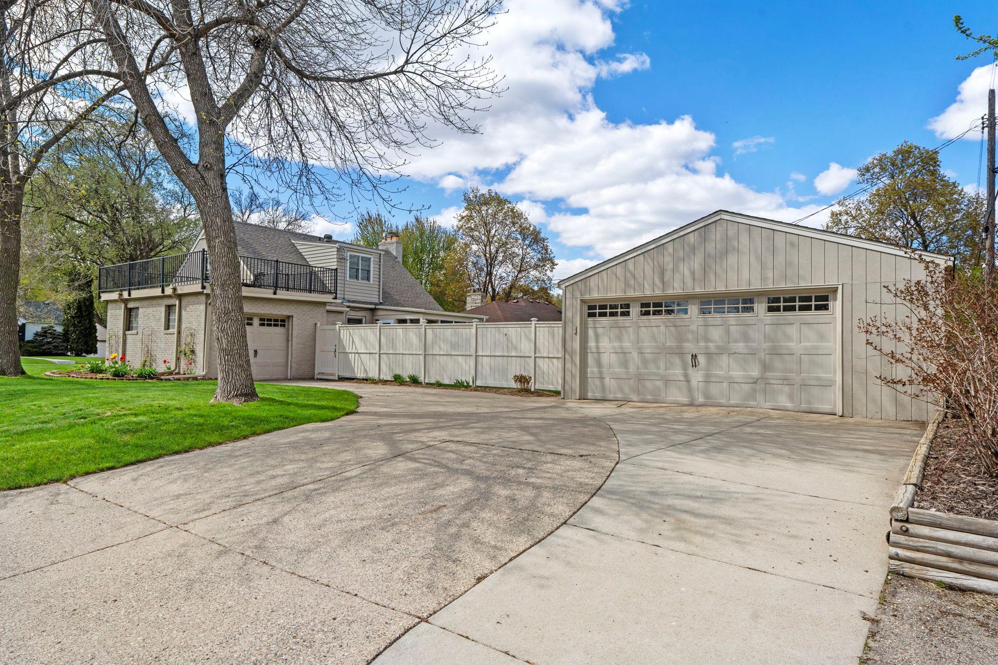 This home features both an attached one-car garage and a detached heated two-car garage, along with a spacious concrete driveway.
