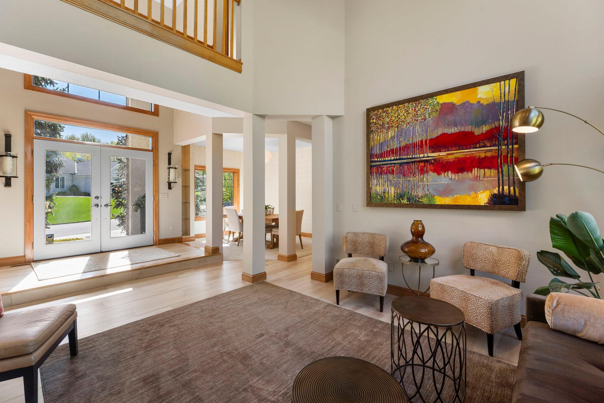 The foyer flows seamlessly into the great room, showcasing updated luxury flooring (2022) that extends throughout the main level.