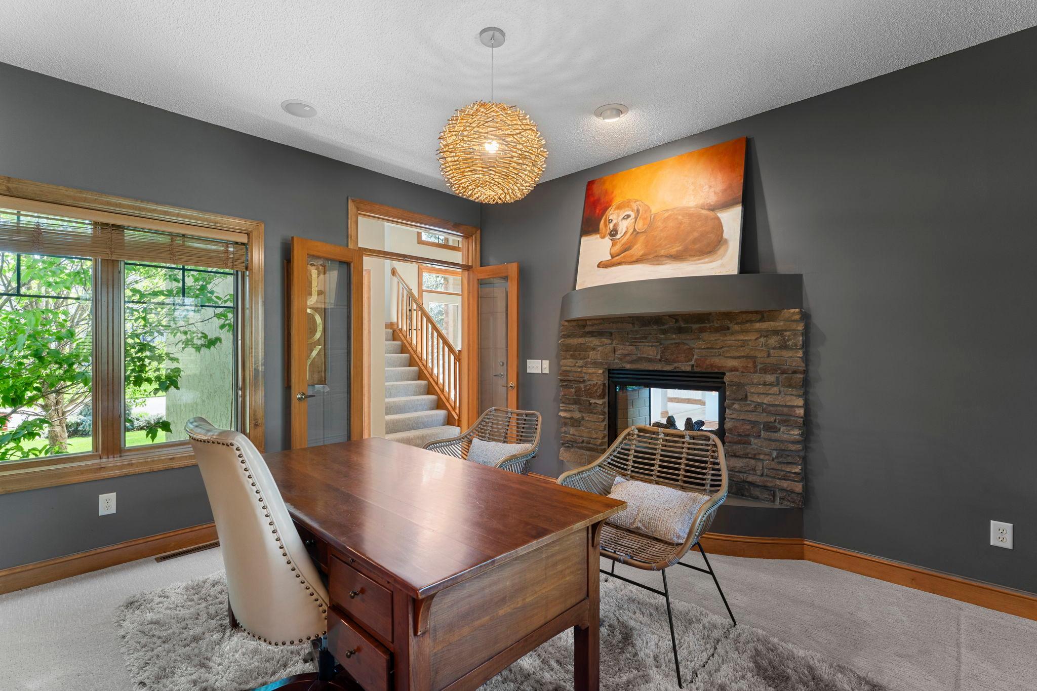 Rounding out the main level is a dedicated office space sharing the double-sided fireplace with the great room.