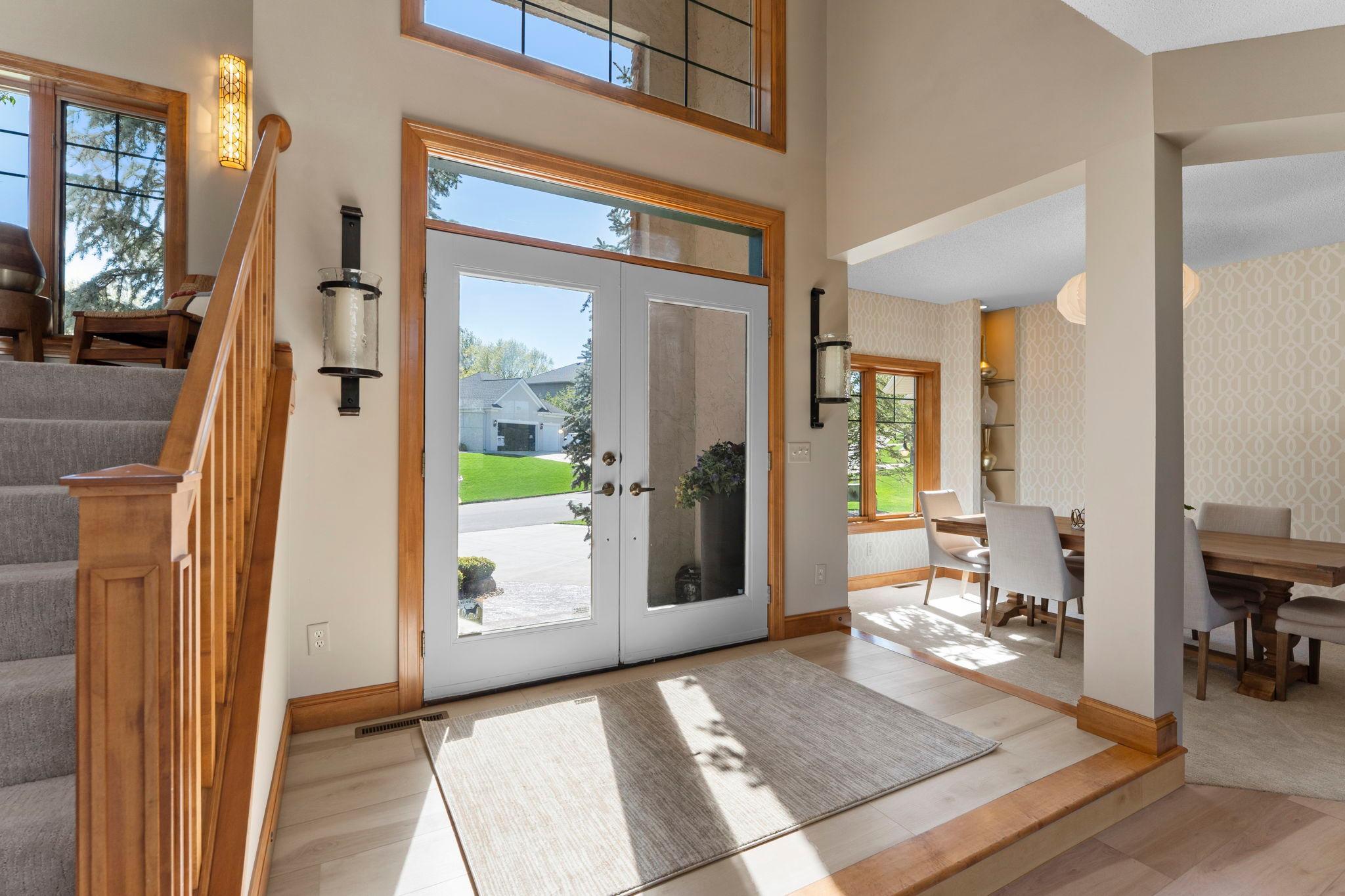 As you enter this stunning home, you are welcomed by double French doors opening into a bright and inviting foyer featuring a soaring two-story ceiling and elegant hanging light fixture