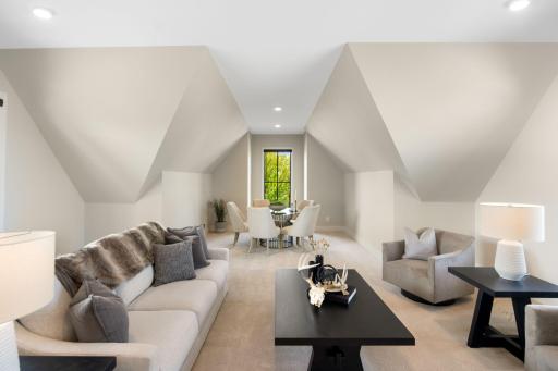 The upper level is thoughtfully designed with two separate wings. The wing accessed from the mudroom, located above the garage, features a spacious bonus room with its own heating and cooling mini-split system for year-round comfort.