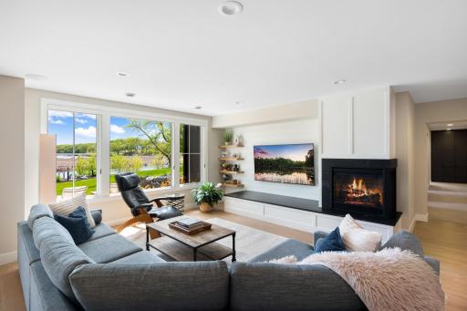 The lower level is an entertainerâs dream. It features a spacious, light-filled family room with white oak hardwood flooring, large picture windows, and a cozy gas fireplace accented by a shiplap feature wall, floating shelves, and recessed lighting.