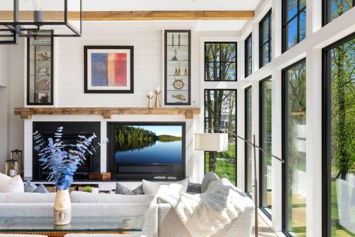 From both the dining room and living room, expansive walls of glass capture truly spectacular views of the beautifully landscaped backyard and the sparkling waters of Lake Minnetonka.
