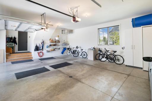 The mudroom leads to the heated and insulated oversized three-car garage, complete with floor drains and built-in storage for added convenience.