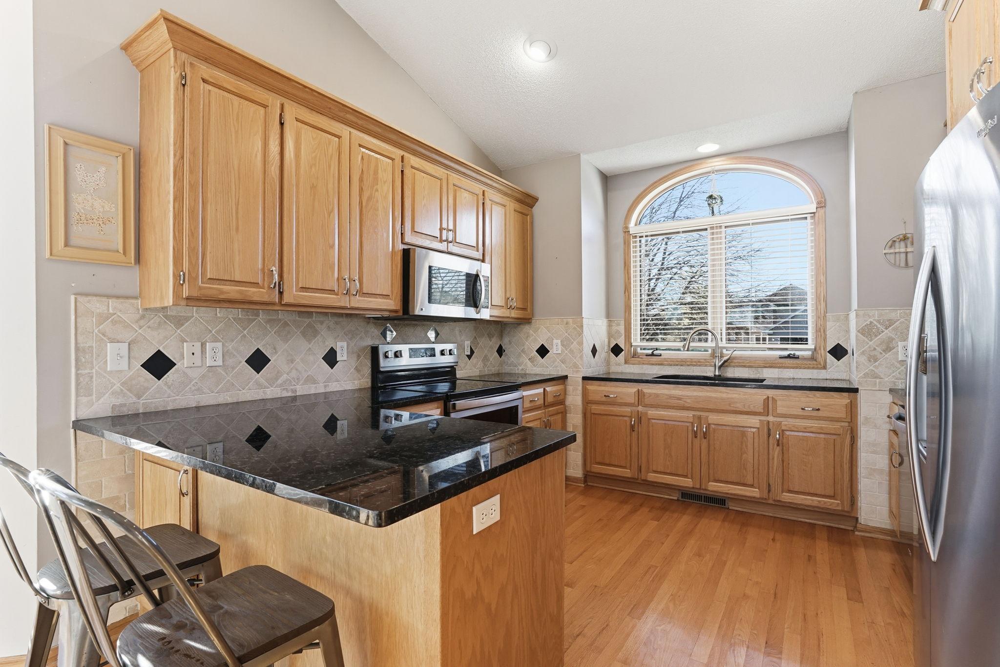 Stone countertops and a designer backsplash add a refined touch.