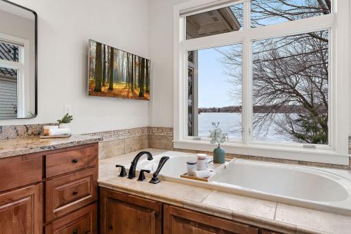Spa-inspired primary bath with jetted tub and tranquil lake views (bath #1)