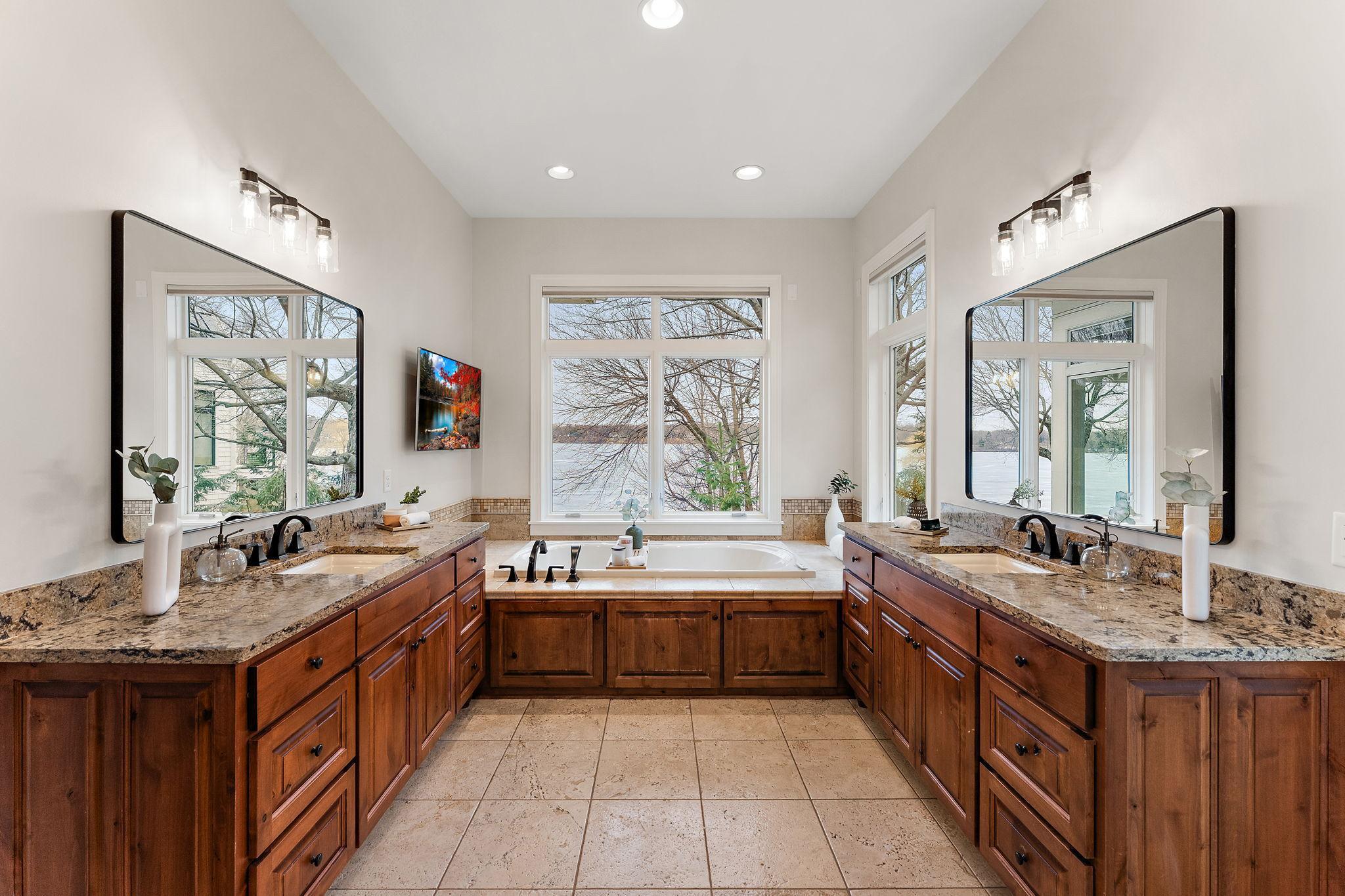 Expansive ensuite bath with dual vanities, in-floor heat, and an abundance of natural light