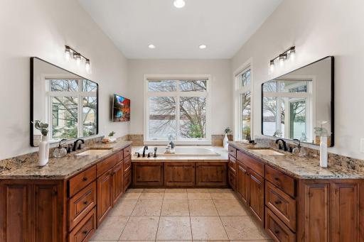 Expansive ensuite bath with dual vanities, in-floor heat, and an abundance of natural light