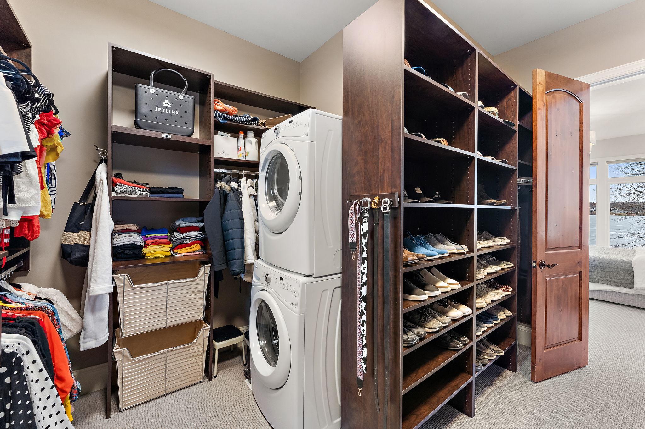 Custom walk-in closet with built-ins and convenient in-closet washer and dryer