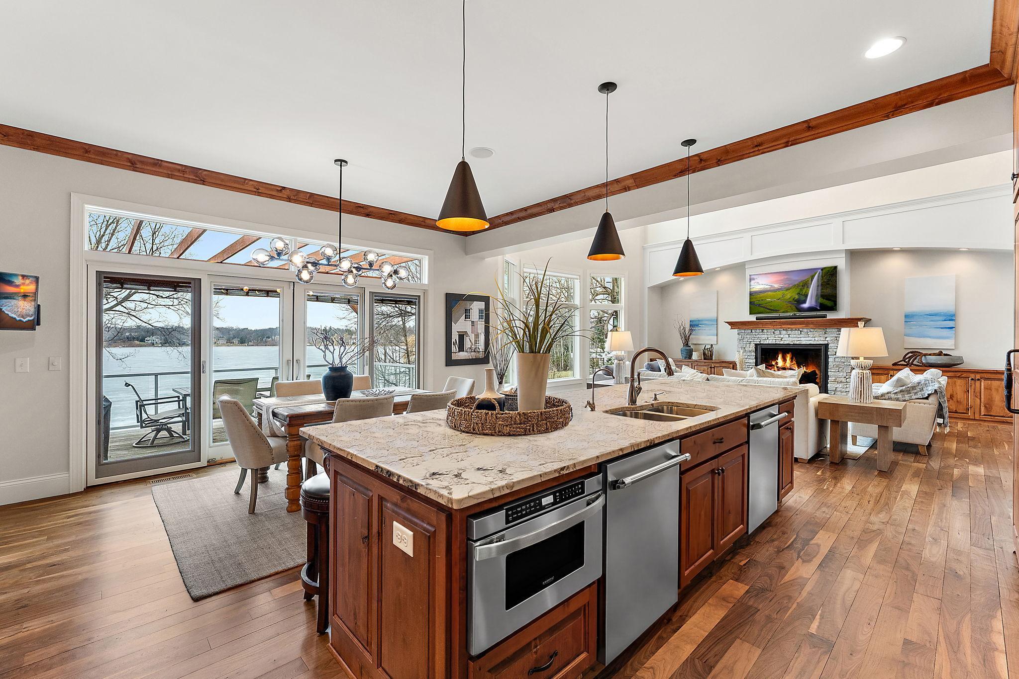 Main-level kitchen featuring Cambria countertops, double dishwasher, and sweeping views of Lake Minnetonka