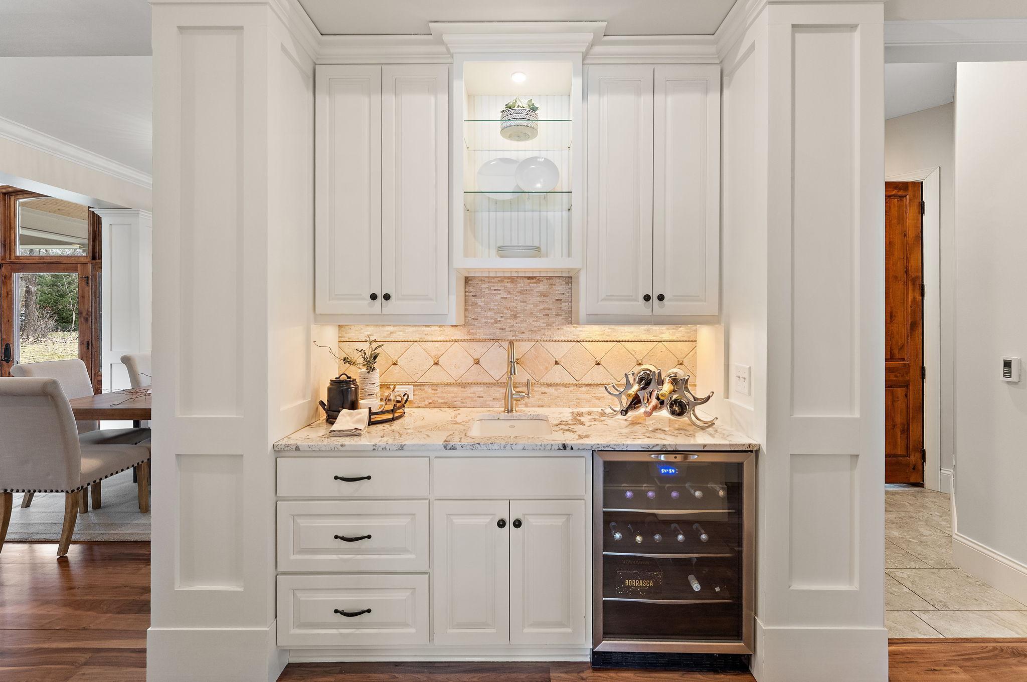 Wet bar with beverage fridge conveniently located near the formal dining room and kitchen