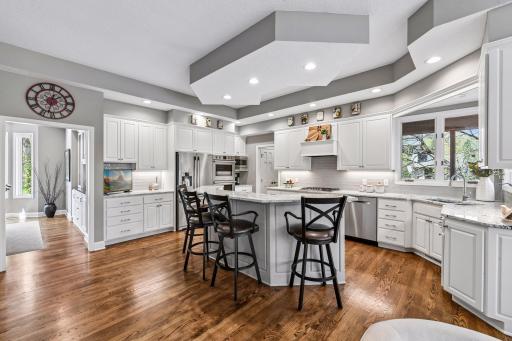 Updated chef's kitchen with large island, wall ovens, cooktop and walk-in pantry