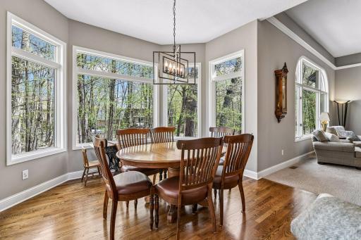 Informal dining nestled into bay surrounded by windows and backyard views