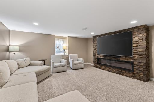 Natural light and fresh finishes in this amazing lower level family room, complete with cozy electric fireplace and large screen mounted TV (stays with the house!).