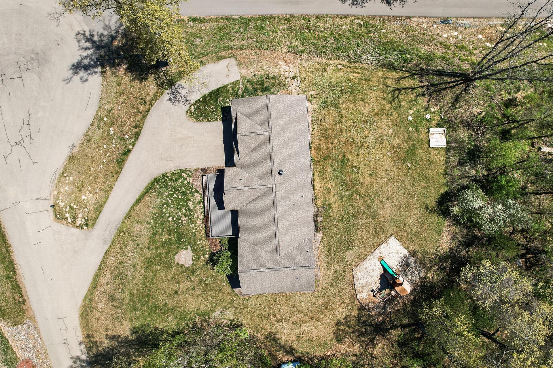Aerial view directly above the 1 acre property, great view of the asphalt driveway with addition for turnaround or extra parking.