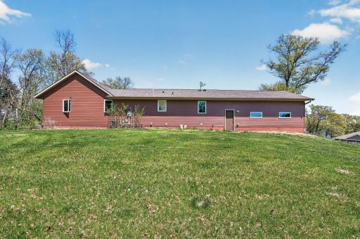 Rearview of the home, steel siding, access to the garage, large level yard.