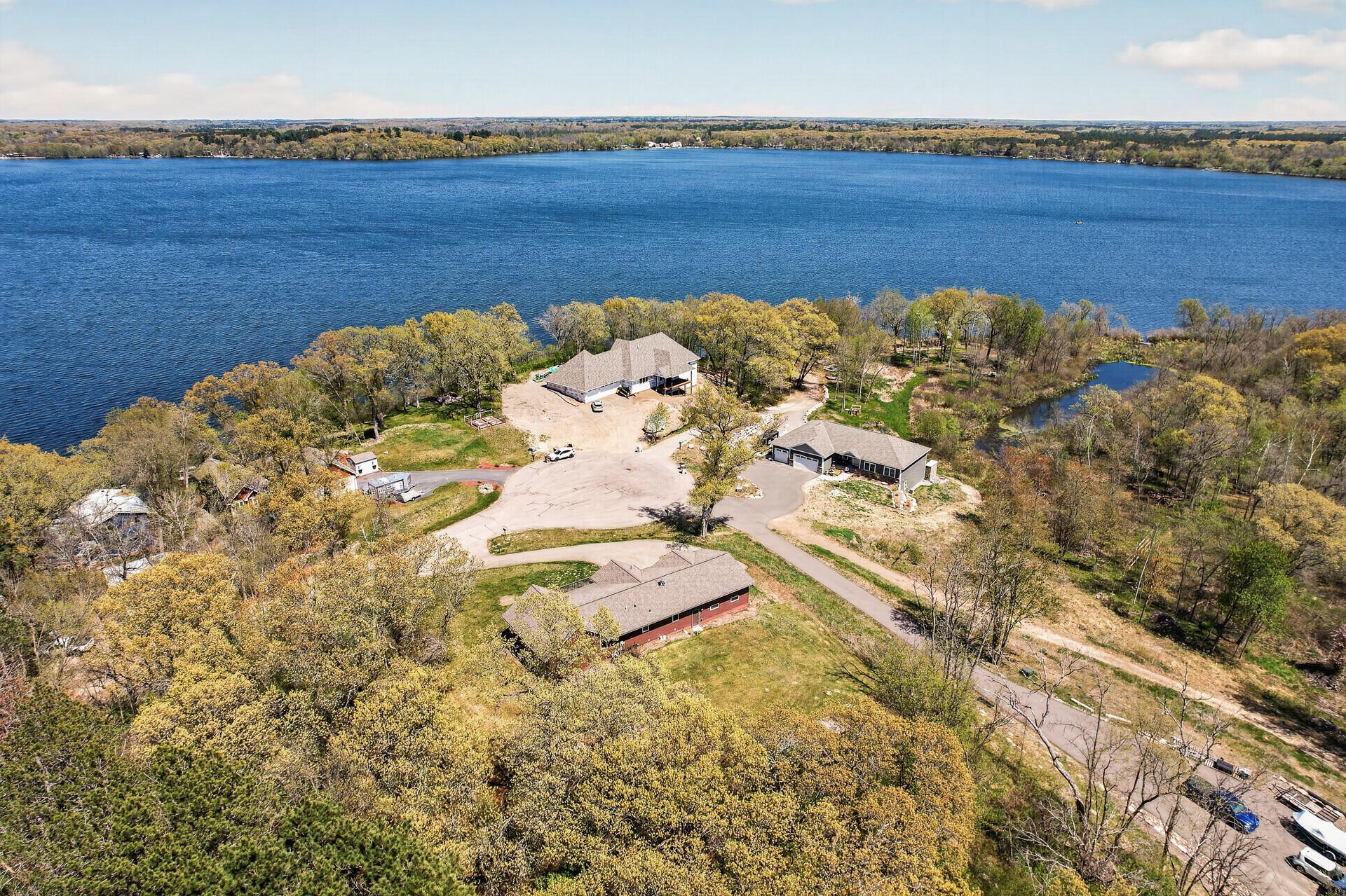 Aerial view from the southwest looking northeast across the lake, rearview of the home and full culdesac view.