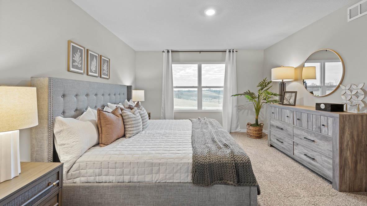 Primary suite with dedicated bathroom and expansive closet. Model home, finishes will vary.