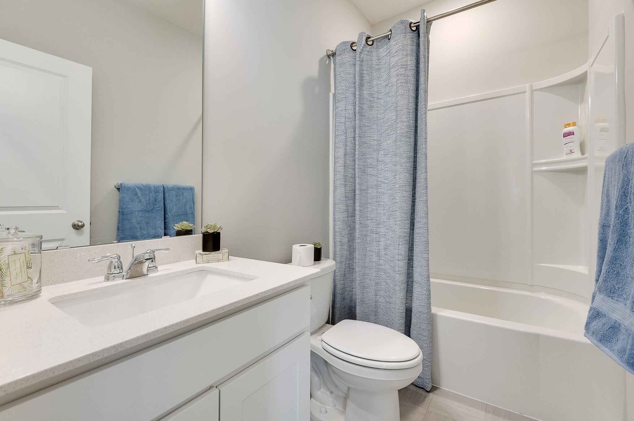 Hall bathroom for the two bedrooms at the front of the house. Model home, finishes will vary.