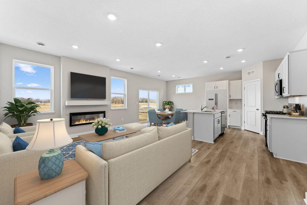 Bright living room with two windows for natural light, dining room with patio doors. Model home, finishes will vary.