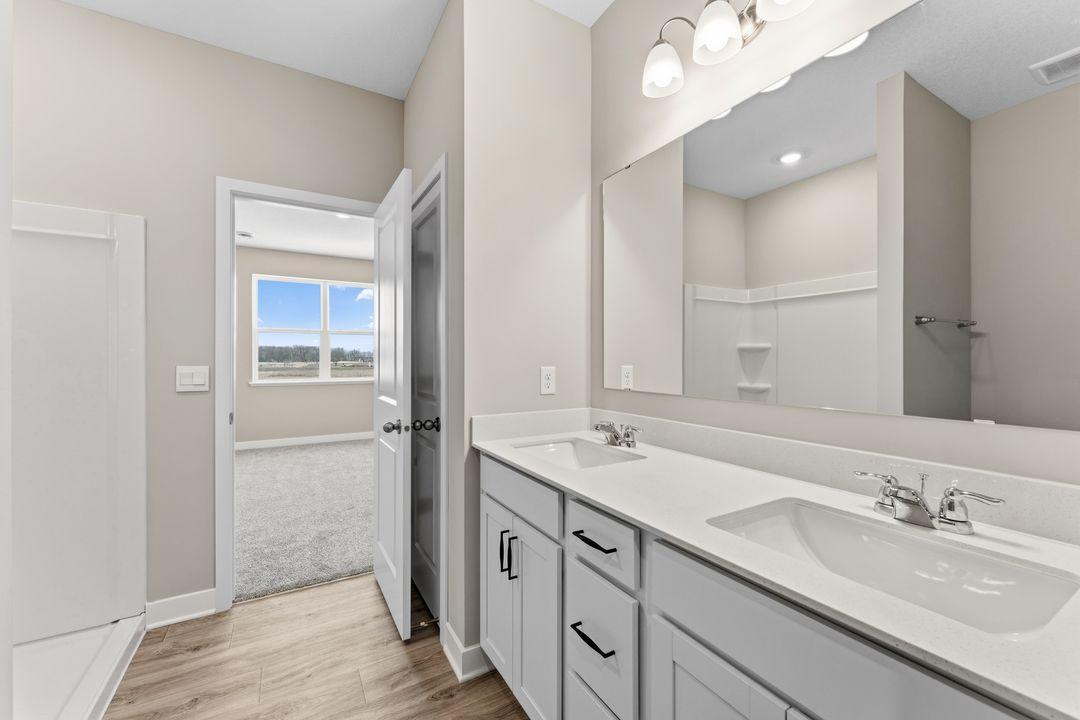 Primary suite with dedicated bathroom and expansive closet. Model home, finishes will vary.