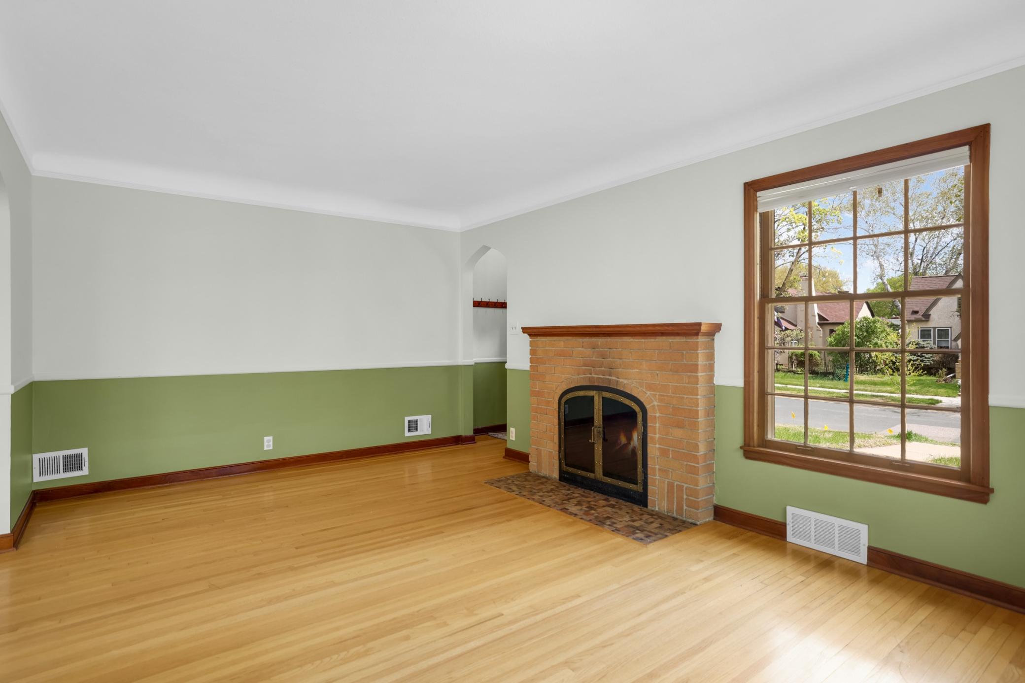 Step into the spacious living room. The fireplace, crown molding, and beautiful hardwood floors add to the charm of the space!