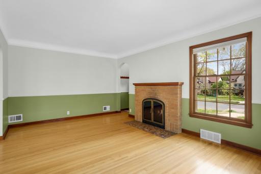 Step into the spacious living room. The fireplace, crown molding, and beautiful hardwood floors add to the charm of the space!