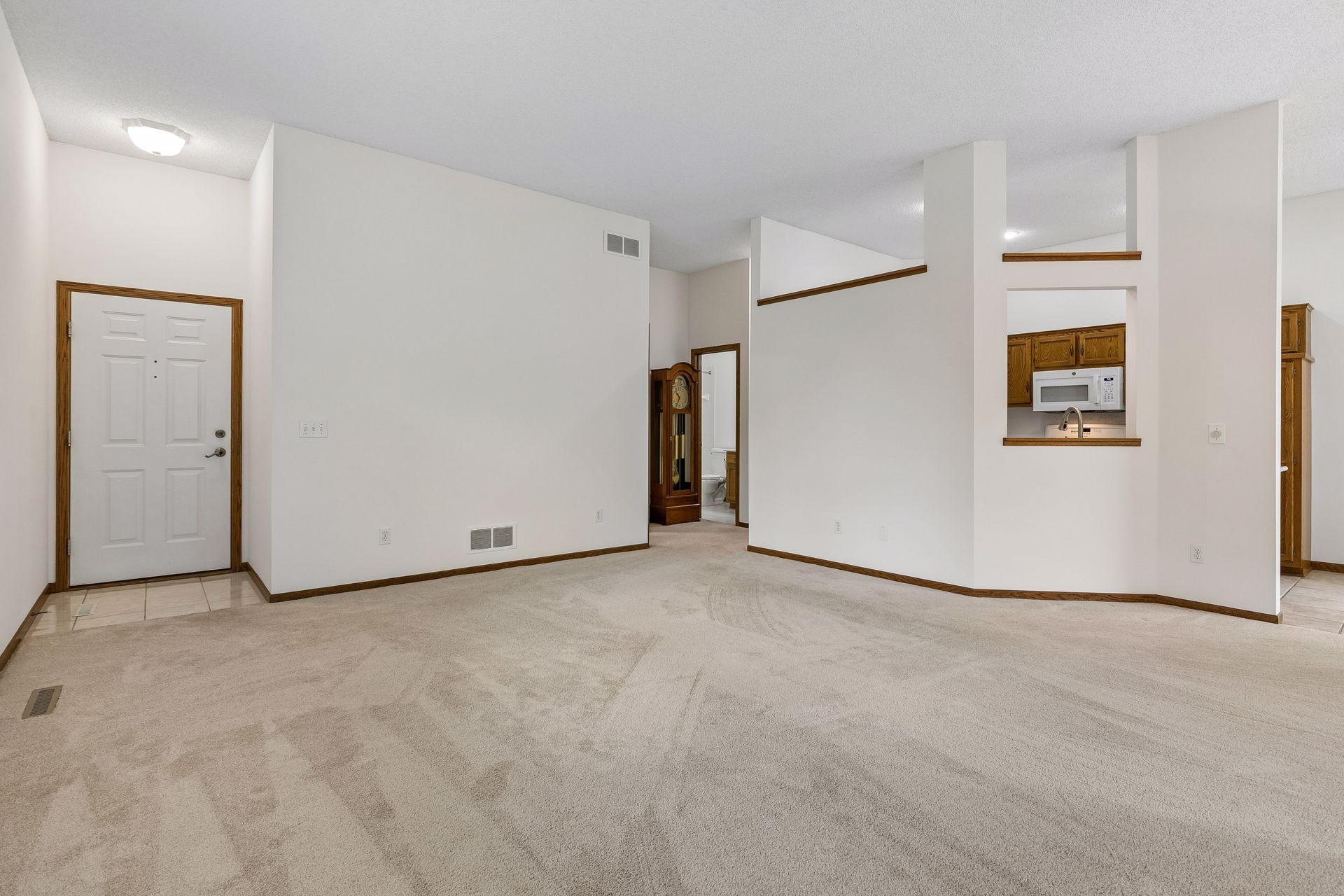 Looking towards the front door, kitchen, and hallway to bedrooms