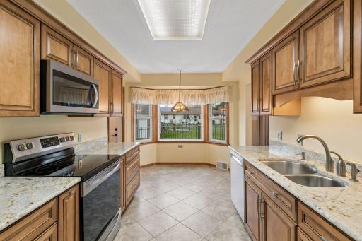 The kitchen features newer cherry cabinets, granite counters, newer flooring, and newer appliances.
