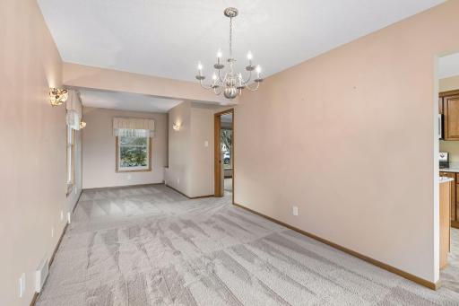 View of dining room and den, door to right is in to the living room. We do not think this room has hardwood flooring under the carpet.