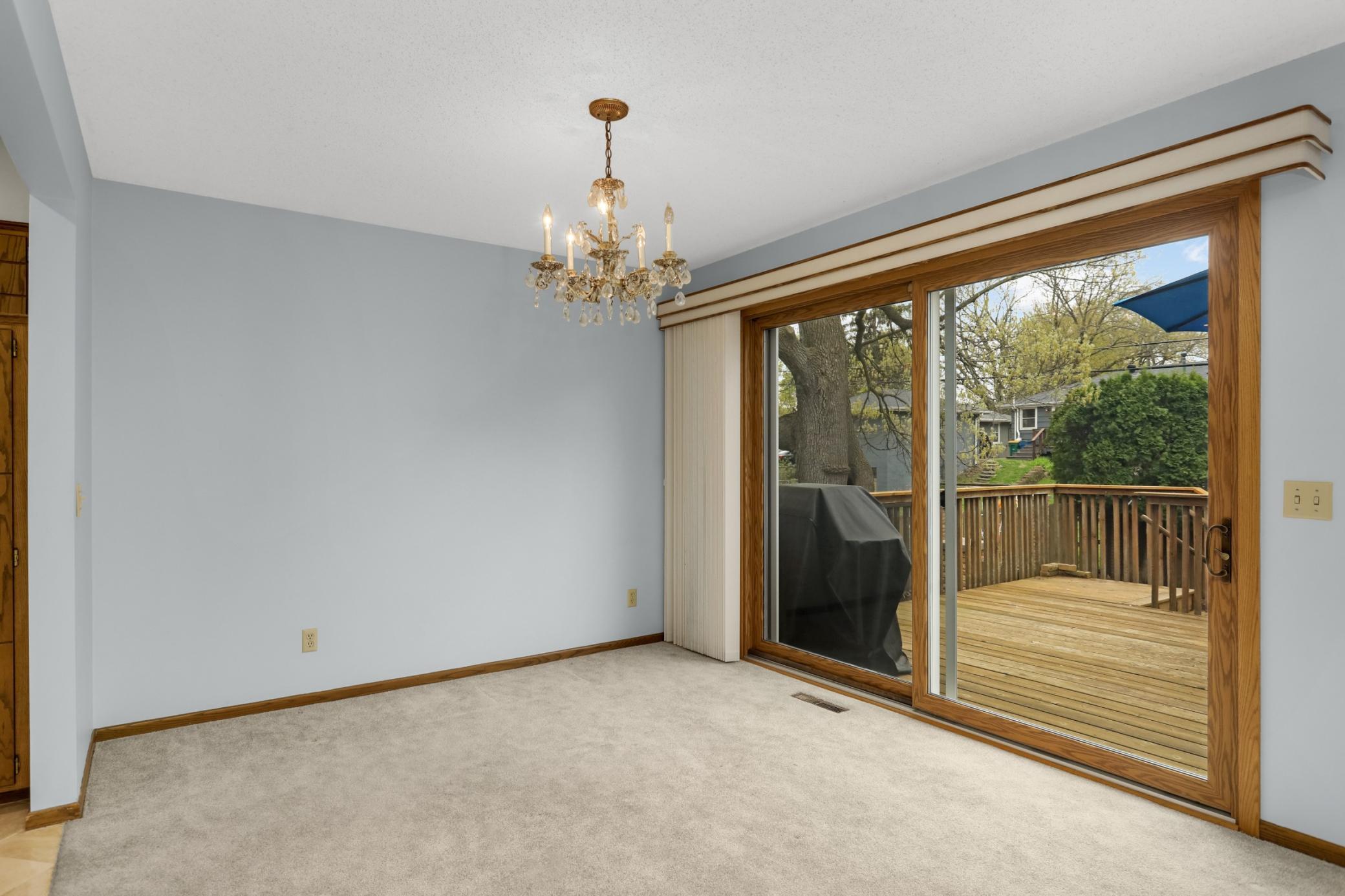 Formal dining with large over sized sliding glass doors to deck. Newer Hunter Douglas vertical blinds.