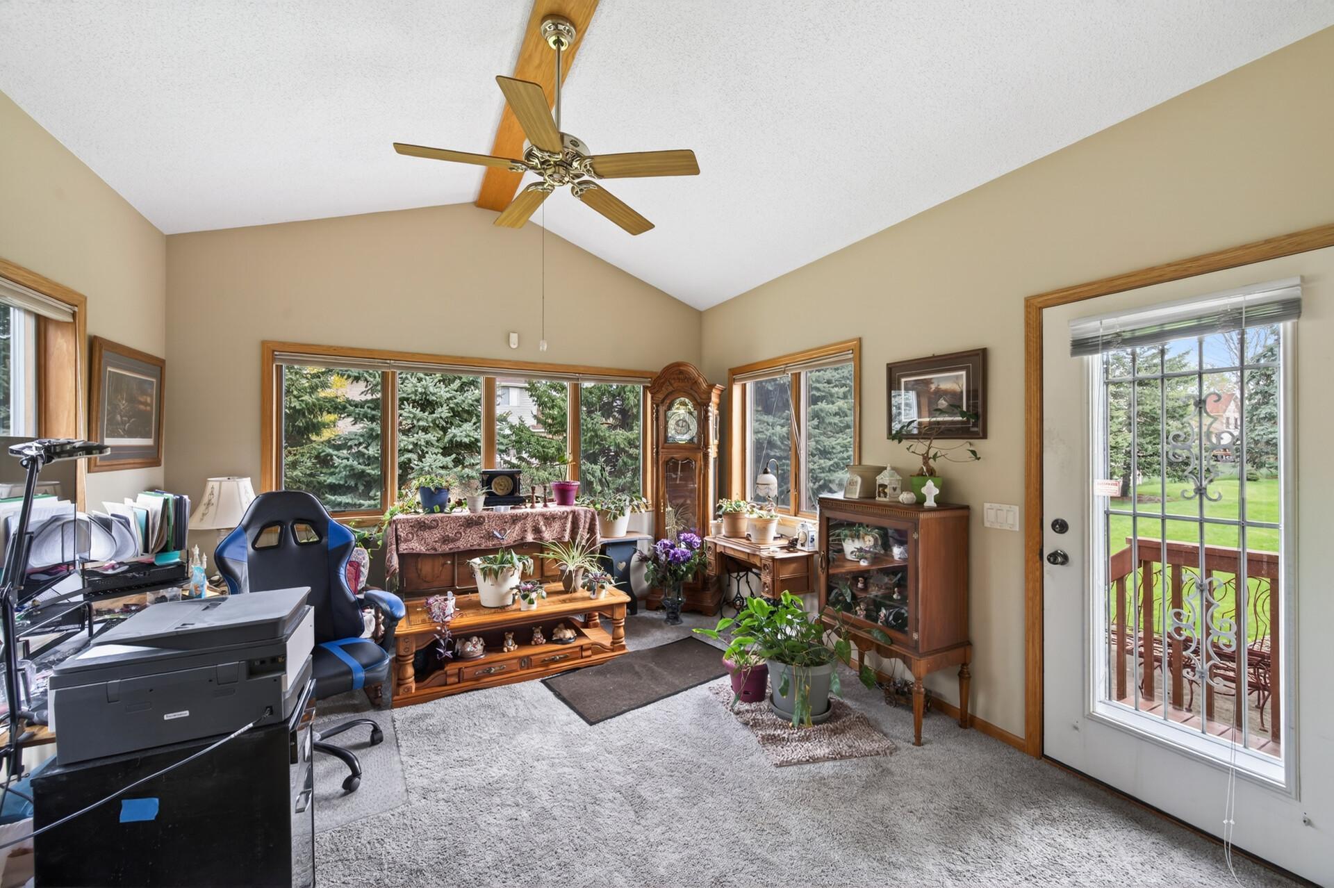 Step into the 4-season porch featuring vaulted ceilings, windows on each wall, and a ceiling fan for added comfort.