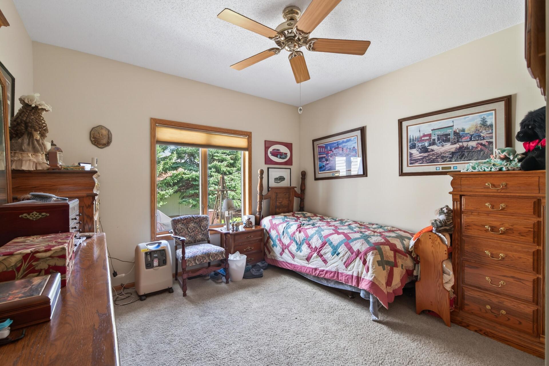 Secondary bedroom with plush carpeting, neutral tones, and abundant natural light.