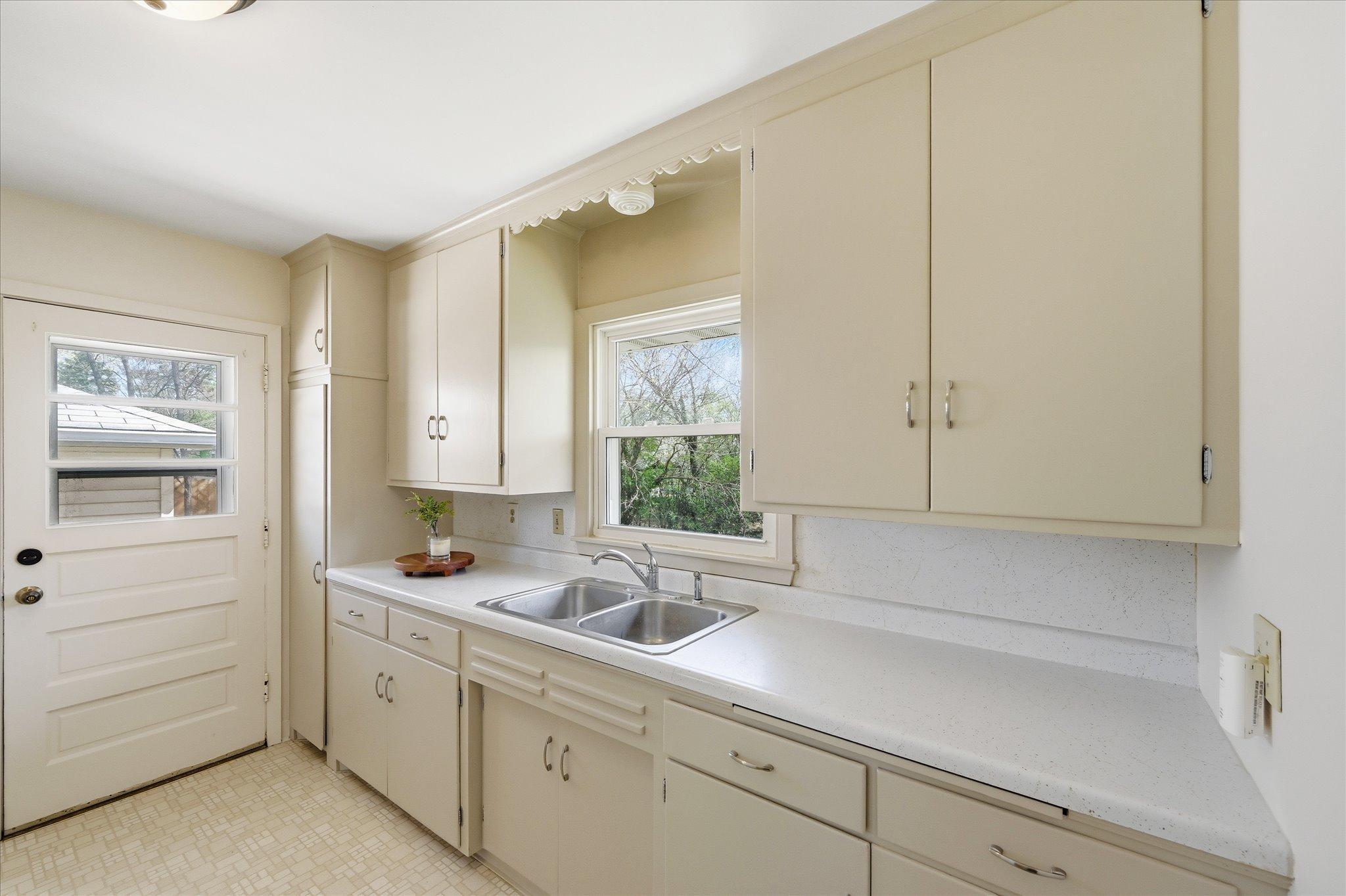 Long kitchen with plenty of cabinet space and steps out to private patio.