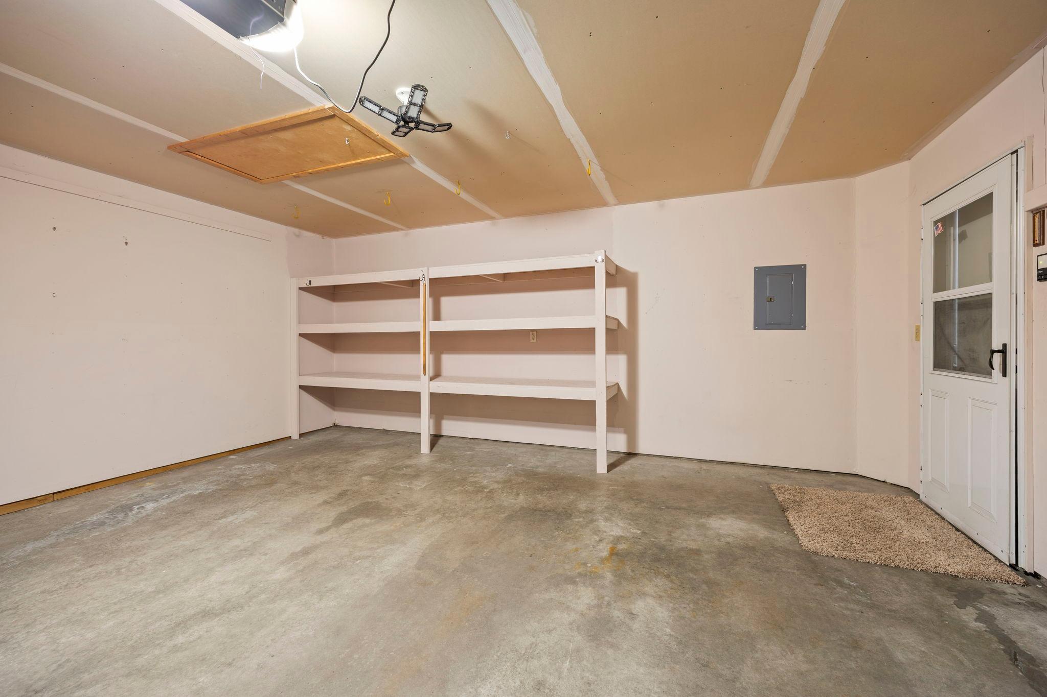 The garage has this storage shelving, and you can see the pull-down storage ladder in the ceiling.