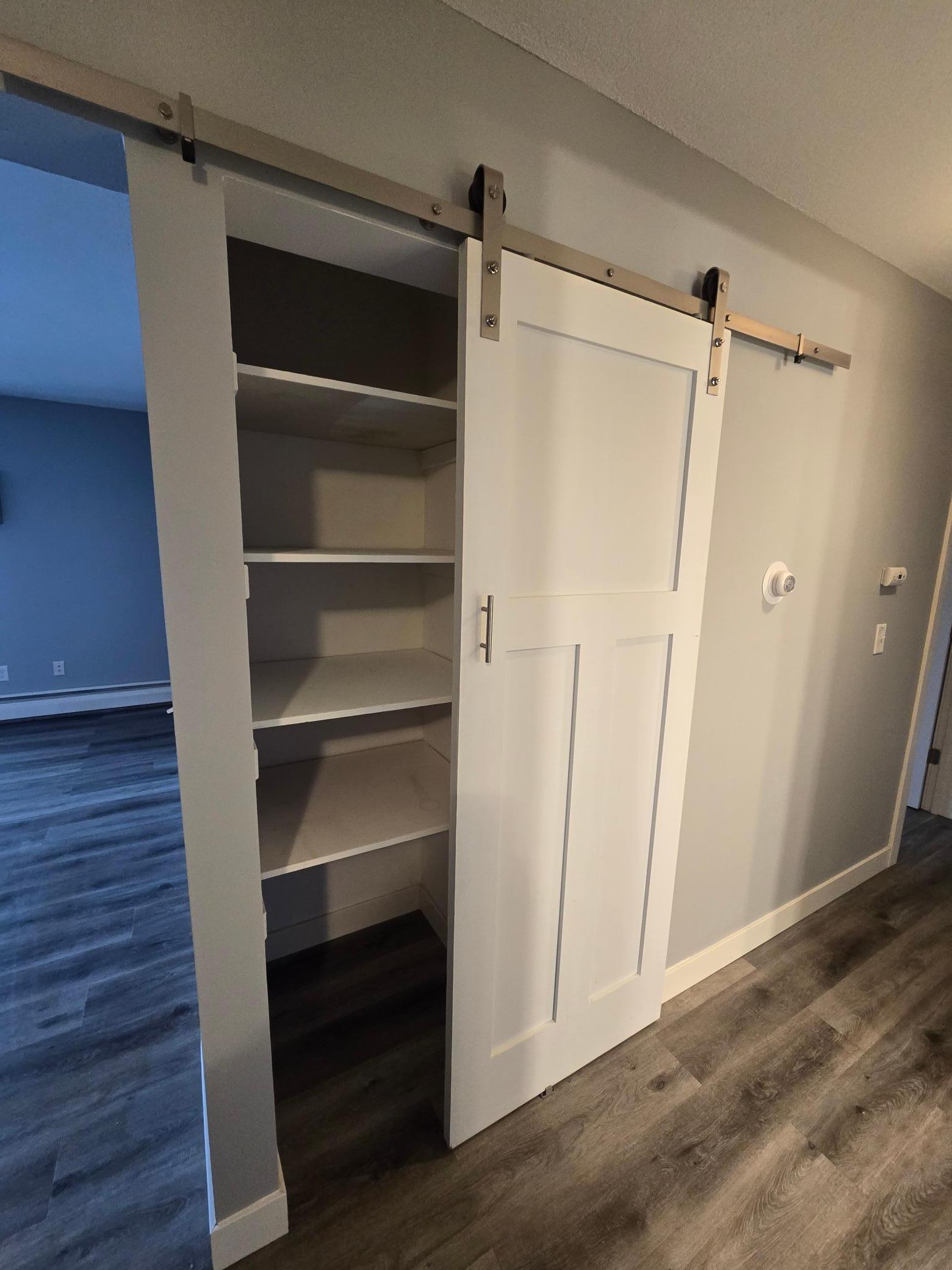 Hallway linen closet with sliding barn door